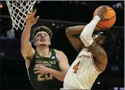  ?? MIKE STEWART — THE ASSOCIATED PRESS ?? Texas guard Tyrese Hunter, right, shoots against Colorado State guard Joe Palmer during the first half on Thursday in Charlotte, N.C.