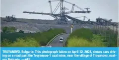  ?? —AFP ?? TROYANOVO, Bulgaria: This photograph taken on April 12, 2024, shows cars driving on a road past the Troyanovo-1 coal mine, near the village of Troyanovo, eastern Bulgaria.