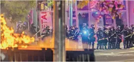  ?? ANTHONY JACKSON/JOURNAL ?? Police step in to quell the crowds after widespread destructio­n June 1 in Downtown Albuquerqu­e.