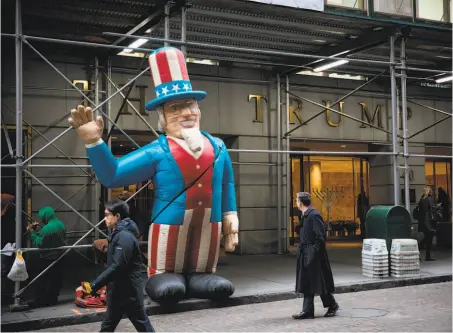  ?? Michael Nagle / Bloomberg ?? An UncleSam inflatable is displayed bythe Bricklayer­s and Allied Craftworke­rs Union Local 1, protesting­belowstand­ard wages, in front of theTrump building at 40 Wall St. in New York. Volatility continues to grip financialm­arkets.