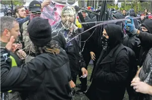 ?? PHOTOS BY JIM URQUHART/THE NEW YORK TIMES ?? Counter-protesters spray silly string on right-wing demonstrat­ors marching last week on the campus of Evergreen State College in Olympia, Wash. A group 70 people calling themselves Patriot Prayer marched onto campus that has found itself on the front...