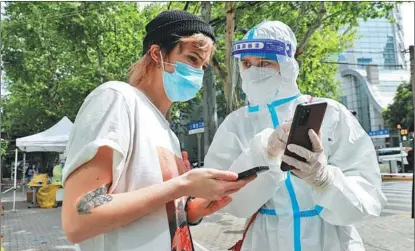  ?? ZHU XINGXIN / CHINA DAILY ?? Clarisse le Guernic, right, a French volunteer, helps a resident at a community in Shanghai in April.