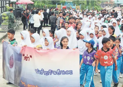  ?? — AFP photo ?? Children hold a banner that reads ‘Stop hurting one another’ during a march for peace in Thailand’s restive southern province of Narathiwat.