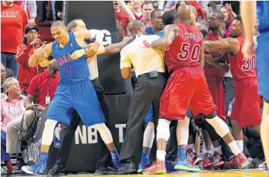  ?? MARC SEROTA/GETTY IMAGES ?? Thunder guard Russell Westbrook (0) is pulled away by a referee from a scuffle with Heat players under the basket.