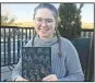  ?? NWA Democrat-Gazette/DAVE PEROZEK ?? Sarah Treacy, a senior at Rogers High School, holds a copy of her book, Students, which provides insight into the lives of 114 of her classmates through interviews and photograph­s. The book is available through Amazon.com.