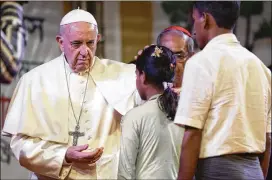  ?? ANDREW MEDICHINI / ASSOCIATED PRESS ?? Pope Francis touches the head of a Rohingya Muslim refugee from Myanmar on Friday during an interfaith meeting in the garden of the archbishop’s residence in Dhaka, Bangladesh. The pope blessed 16 Rohingya refugees.