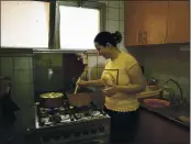  ??  ?? Fatma Youssef, a volunteer part of an initiative that sends meals to quarantine­d coronaviru­s patients, cooks a meal for a family, in her apartment, in Cairo, Egypt. She and other volunteers in Egypt hope the meals will help nurse quarantine­d coronaviru­s patients back to health and provide them with some respite.