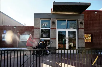  ?? PHOTOS BY HELEN H. RICHARDSON — THE DENVER POST ?? Michael Wooten, an Independen­t Life Skills trainer, left, pushes his client Dennis Gonzales in his wheelchair to go work out at the Athmar Recreation Center in Denver on Tuesday. Denver rec centers are changing their hours amid budget cuts.