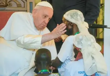  ?? GREGORIO BORGIA/AP ?? Pope Francis strokes the face of a victim of violence Wednesday in Kinshasa, Congo. While celebratin­g a Mass for over 1 million people in the Congolese capital, Francis urged followers to forgive those who committed “inhuman violence” against them. The 86-year-old pontiff’s tour of Africa, which includes a stop in neighborin­g South Sudan, will end Sunday.