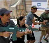  ??  ?? Foreign tourists train with wooden guns during an “anti-terrorism” course in the West Bank —