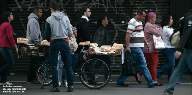  ??  ?? Ambulante vende pães em bicicleta pela avenida Paulista, SP