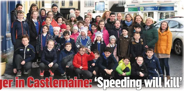  ?? Photo by Michelle Cooper Galvin ?? RIGHT: Local residents and schoolchil­dren in Castlemain­e village on Monday.