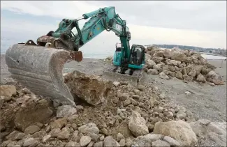  ?? (Photo Cyril Dodergny) ?? Une pelle mécanique stocke des blocs de calcaire de trois tonnes, ce mercredi, sur la plage du Casino.