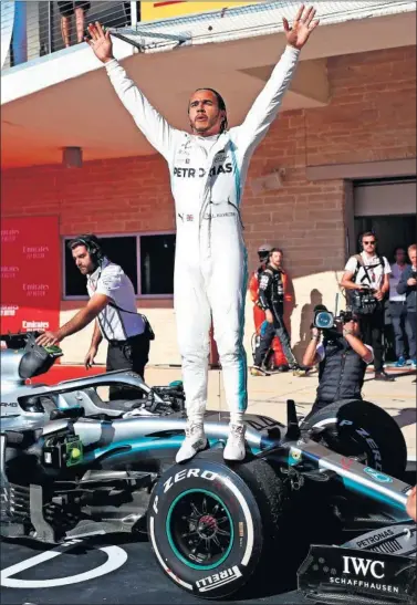  ??  ?? Lewis Hamilton celebra su sexto título mundial subido sobre su Mercedes en el parque cerrado de Austin.