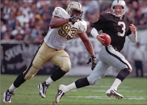  ?? (AP file photo) ?? Wayne Martin, here chasing Oakland Raiders quarterbac­k Jeff George during a 1997 game, played his entire profession­al career with the New Orleans Saints. Martin, a Cherry Valley native and All-Southwest Conference standout defensive lineman at the University of Arkansas, remains the Razorbacks’ record holder in career sacks (25.5) and single-game sacks (5).