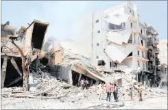  ??  ?? Local residents inspect the damage after airstrikes by Turkey.