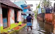  ?? FILE PHOTO ?? A man walks through a waterlogge­d street following heavy downpour