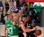  ?? (AP Photo/Mark J. Terrill) ?? Miami’s Tyler Herro (right) looks to pass around Boston’s Daniel Theis during the Heat’s 112-109 victory over the Celtics in Game 4 of the Eastern Conference finals Wednesday night. Herro came off the bench to lead all scorers with 37 points.