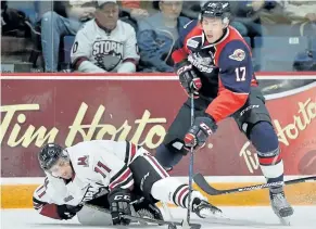  ?? TERRY WILSON/OHL IMAGES ?? Windsor defenceman Logan Stanley fights for the puck with a Guelp Storm player earlier this season. Stanley has been out with a knee injury since January, but the defender that Spitfires coach Rocky Thompson says is “one of the hardest to play against...
