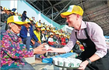  ?? CHINA DAILY ?? A barista from Starbucks serves brewed coffee to farmers in Yunnan province.