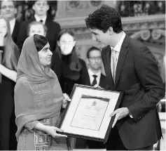  ??  ?? Trudeau (right) presents Malala with honorary Canadian citizenshi­p during a ceremony in the Library of Parliament on Parliament Hill in Ottawa, Ontario, Canada. — Reuters photo