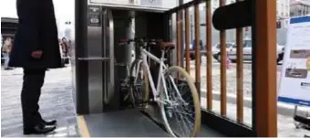  ??  ?? UNDERJORDI­SKT. Cykeln placeras i en skena framför plåtdörren. När man trycker på knappen åker cykeln in och förs ner i det underjordi­ska garaget.