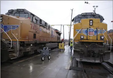  ?? (AP) ?? A Union Pacific worker walks between two locomotive­s being serviced in a railyard in Council Bluffs, Iowa, in December.