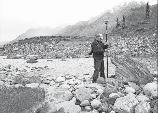  ?? [DAN SHUGAR/UNIVERSITY OF WASHINGTON-TACOMA] ?? Researcher Jim Best measures water levels on the Slims River in September 2016. After ‘river piracy’ stole meltwater from the basin, dust clouds were seen along the Slims.