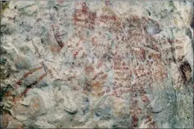  ?? LUC-HENRI FAGE — KALIMANTHR­OPE.COM VIA AP ?? This composite image from the book “Borneo, Memory of the Caves” shows the world’s oldest figurative artwork dated to a minimum of 40,000 years, in a limestone cave in the Indonesian part of the island of Borneo. Scientists say the red silhouette of a bull-like beast, upper left, is the oldest known example of animal art.