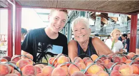  ?? SCOTT ROSTS
METROLAND ?? Parm Borozny and Jesse Brouwer of DeVries Fruit Farm in Pelham ensure fresh peaches are ready for customers.