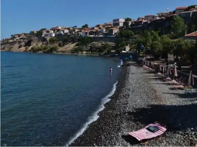  ?? LOUISA GOULIAMAKI PHOTOS/AFP/GETTY IMAGES ?? The sea of humanity that arrived on the shores of Lesbos last year took a toll on the Aegean island’s tourism industry.