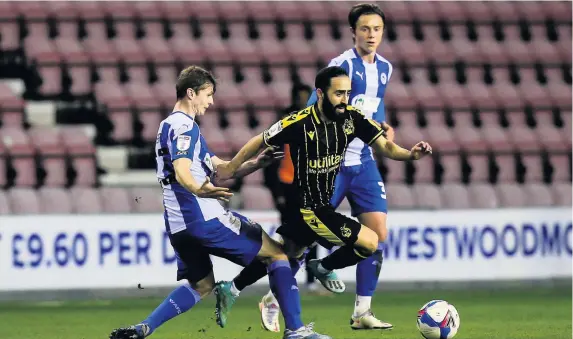  ?? Picture: Robbie Stephenson/JMP ?? Rovers midfielder Erhun Oztumer tries to get past Wigan’s Chris Merrie at the DW Stadium