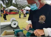  ?? PHOTO BY MARNI JAMESON ?? Gregg Kurtz, owner of Chef’s Edge, sharpens knives for customers every weekend at the Winter Park and Mount Dora farmers markets in Florida.