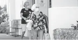  ?? AMY BETH BENNETT/SOUTH FLORIDA SUN SENTINEL ?? Shoppers and employees wear masks at Trader Joe’s grocery store in Boca Raton. Palm Beach County will mail its residents — in about 660,000 homes — a reusable mask.