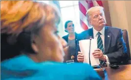  ?? AFP ?? Germany's Chancellor Angela Merkel (left) and US President Donald Trump at a meeting with German and American business leaders in the Cabinet Room of the White House on Friday.