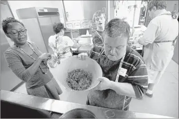  ?? BRANDON DILL/SPECIAL TO THE COMMERCIAL APPEAL ?? Marisa Baggett helps out while Melissa Parham (from left), Warren Curtis, Thomas Robinson and Andy Brooks help prepare ingredient­s for a pot of chili at The Exceptiona­l Foundation kitchen. The team, called Team Fireworks, decided to use chicken in...