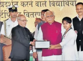  ?? PTI ?? President Pranab Mukherjee presenting a certificat­e to a schoolgirl after laying the foundation stone of a drivers' training institute in Gurugram on Friday.