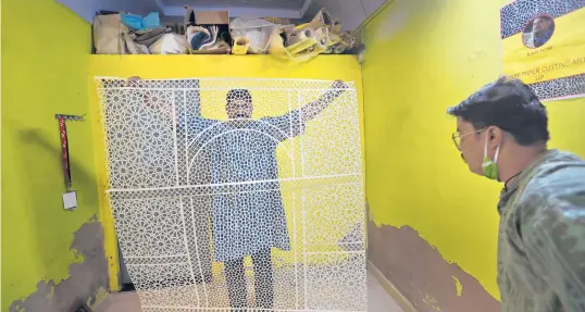  ?? MANISH SWARUP/AP ?? Ram Soni, a paper-cutting artist, shows his work in October at his home in Alwar, India. A couple have launched a campaign called“Empowermen­t through Craft”to help traditiona­l artisans restart sales and trade on an online platform.