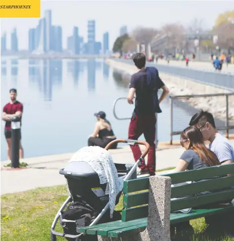  ?? CHRIS YOUNG / THE CANADIAN PRESS ?? People enjoy the warm weather in Toronto on Sunday. Outdoor-based businesses and workplaces in Ontario will be allowed to start up on Monday.