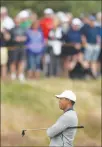  ?? JON SUPER / AP ?? Tiger Woods waits to make a shot Wednesday during a practice round ahead of the British Open Golf Championsh­ip in Carnoustie, Scotland. After a five-year absence, Woods returns to the British Open today.