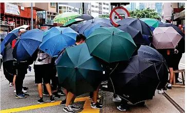  ??  ?? Shield: Protesters with umbrellas, a symbol of the democracy movement, yesterday