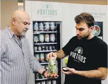  ?? ALLEN McINNIS ?? Aaron Hutman and his son Ryan assemble a salad from their new vending machine installed at Central Station.