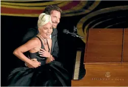  ??  ?? Lady Gaga and Bradley Cooper react to the audience after a performanc­e of Shallow from A Star is Born at the Oscars.