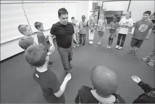  ?? Staff photo by Adam Sacasa ?? Kennedy Center artist Sean Rayne, an actor in the Washington, D.C. area, performs focus and acting exercises with students in Mrs. Owens class Thursday at C.K. Bender Elementary. Rayne demonstrat­ed the exercises to a group of teachers learning to...