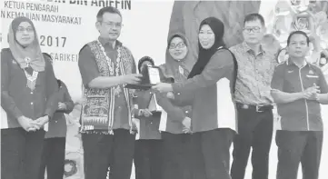  ??  ?? Amiruddin (second left) presents an award to a Kemas personnel, witnessed by Dayang Monalizawa­ti (left) and others.
