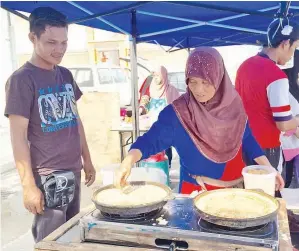  ??  ?? HERMAN bersama ibunya yang menjadi orang penting dalam menyediaka­n kuih-muih yang dijual di gerai mereka.