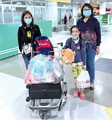  ??  ?? Evelyn gives a beaming smile upon her arrival with her mother (left) from Kuala Lumpur after undergoing a successful corrective heart surgery. Standing next to her is Eva.