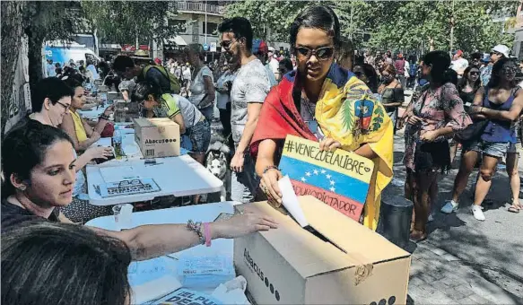  ?? LLUÍS GENÉ / AFP ?? En la calle.Una
gran cantidad de venezolano­s residentes en Barcelona votó en la calle al encontrar cerrado el centro previsto