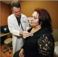  ?? THE ASSOCIATED PRESS ?? Dr. Michael Russum, left, checks patient Ruby Giron in Denver Health Medical Center’s primary care clinic located in a lowincome neighborho­od in southwest Denver.