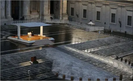  ?? ASSOCIATED PRESS ?? Pope Francis, white figure standing alone at center, delivers an Urbi et orbi prayer from the empty St. Peter’s Square, at the Vatican, Friday, March 27, 2020. Because of the COVID-19 pandemic, the Vatican on Friday announced that Francis will celebrate Mass for Palm Sunday, on April 5, Holy Thursday, on April 9and Easter vigil and Easter Sunday on the weekend of April 11-12, all at the basilica’s central altar.